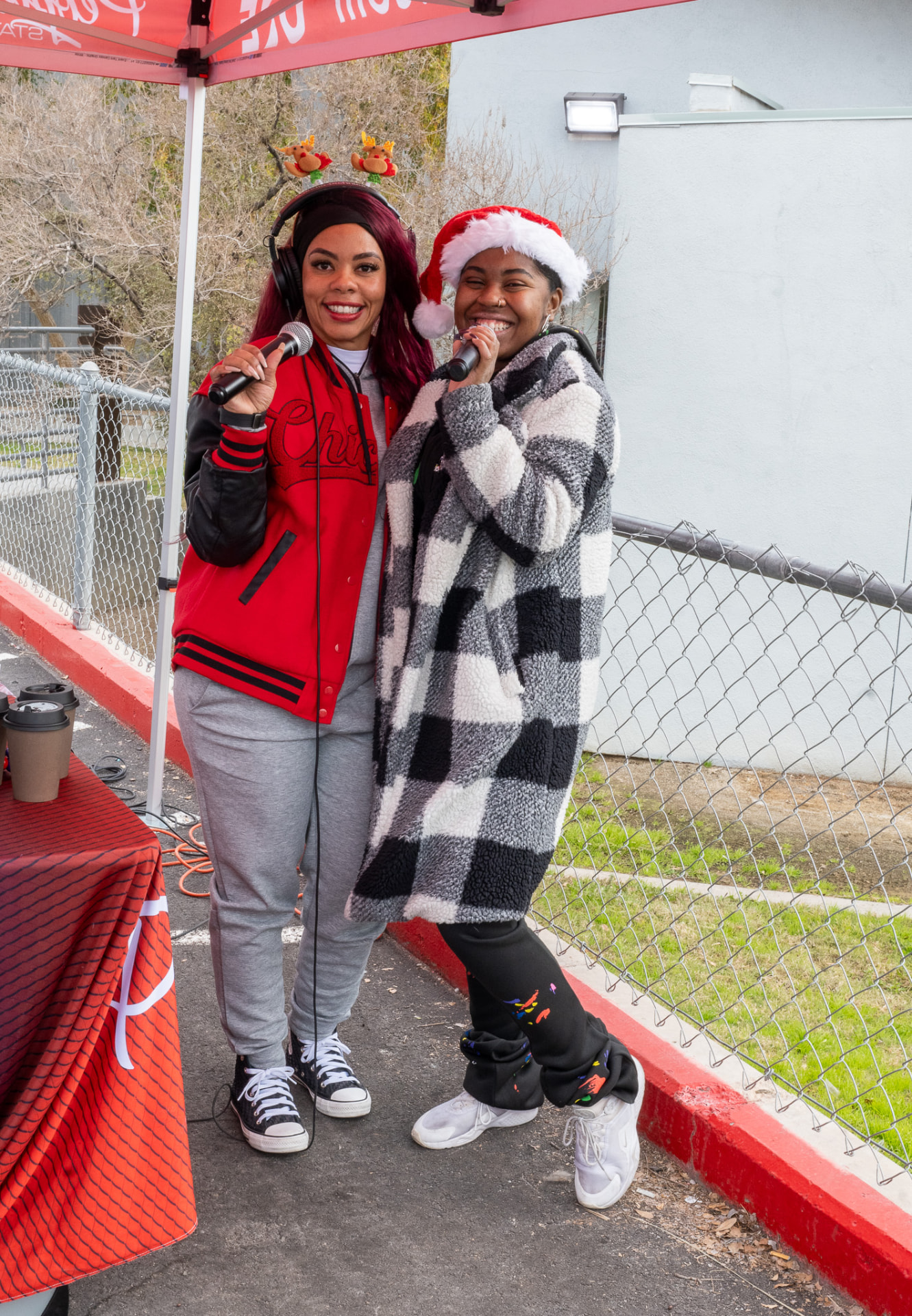 Two hosts on the mic at a holiday community drive
