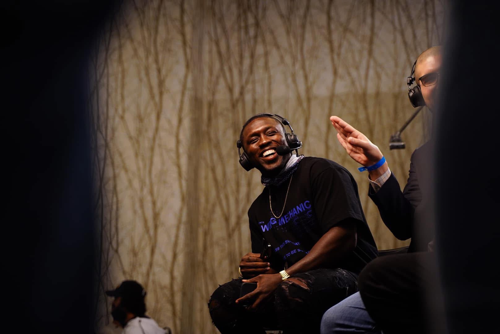 Athlete laughing during a headset interview at a media event