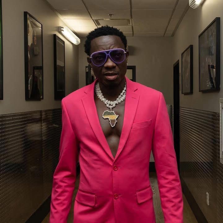 Comedian in a pink suit backstage in a venue hallway