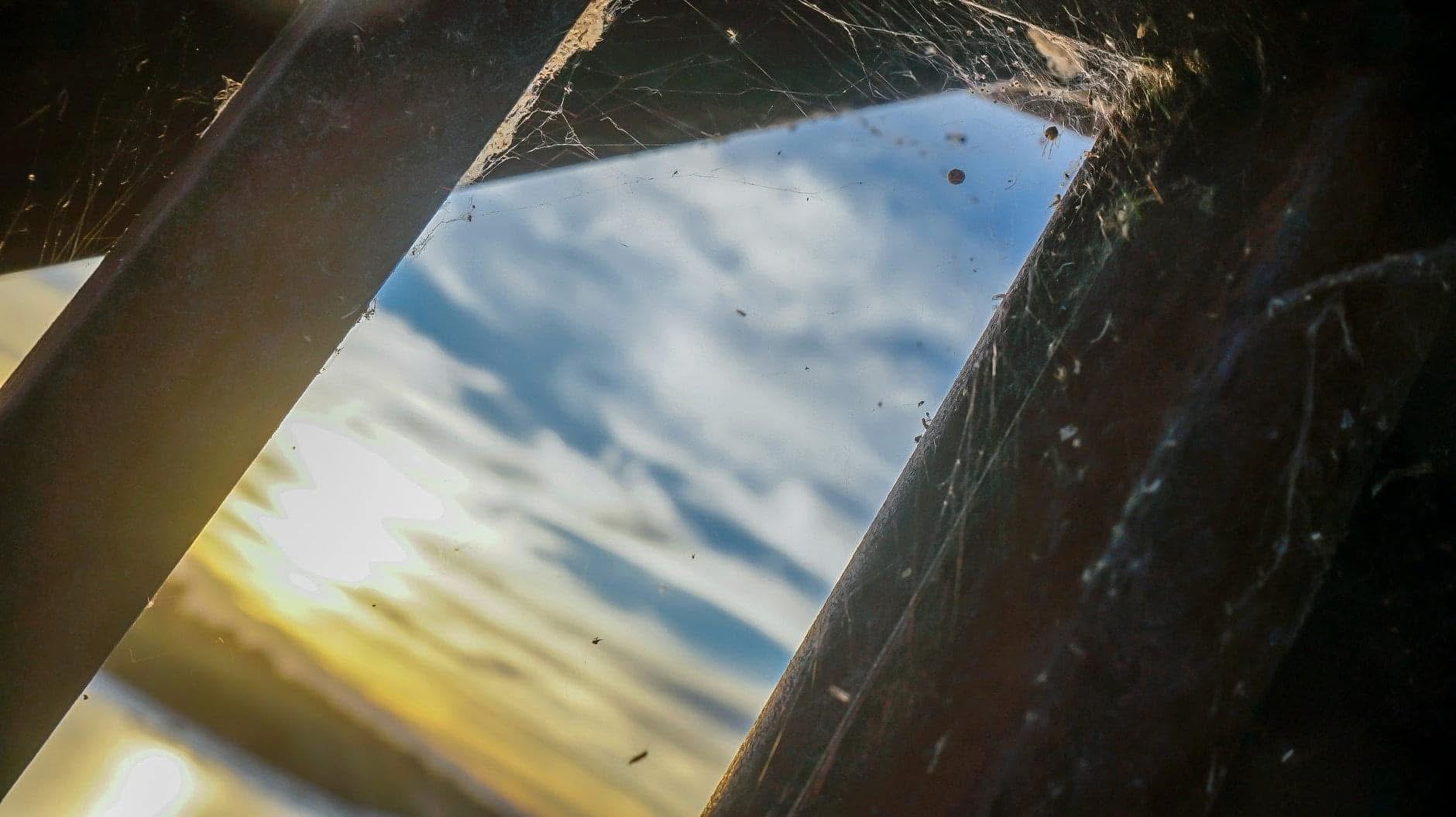 Abstract view of sky and water framed through weathered beams