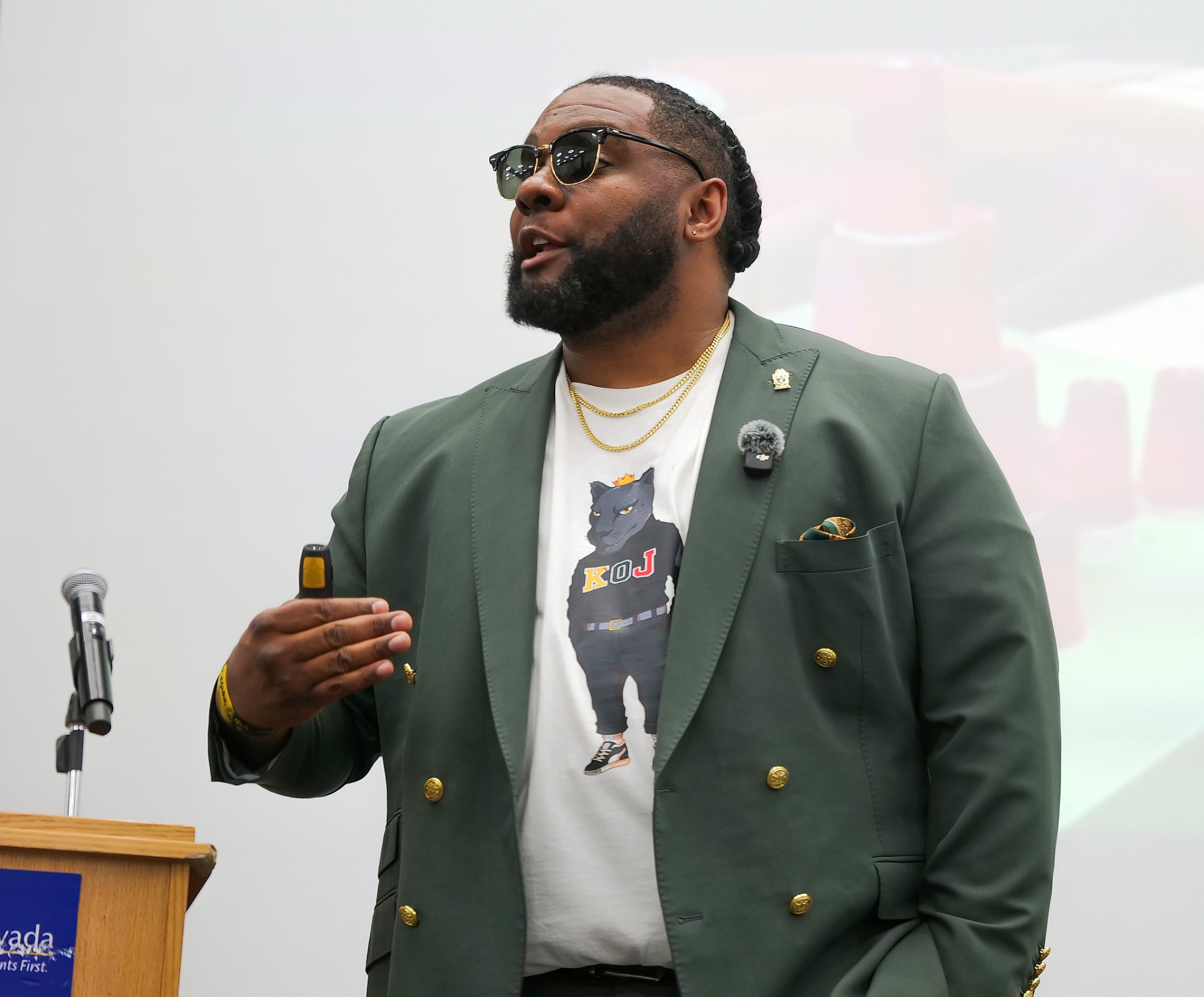 Speaker in a green blazer addressing a youth workshop