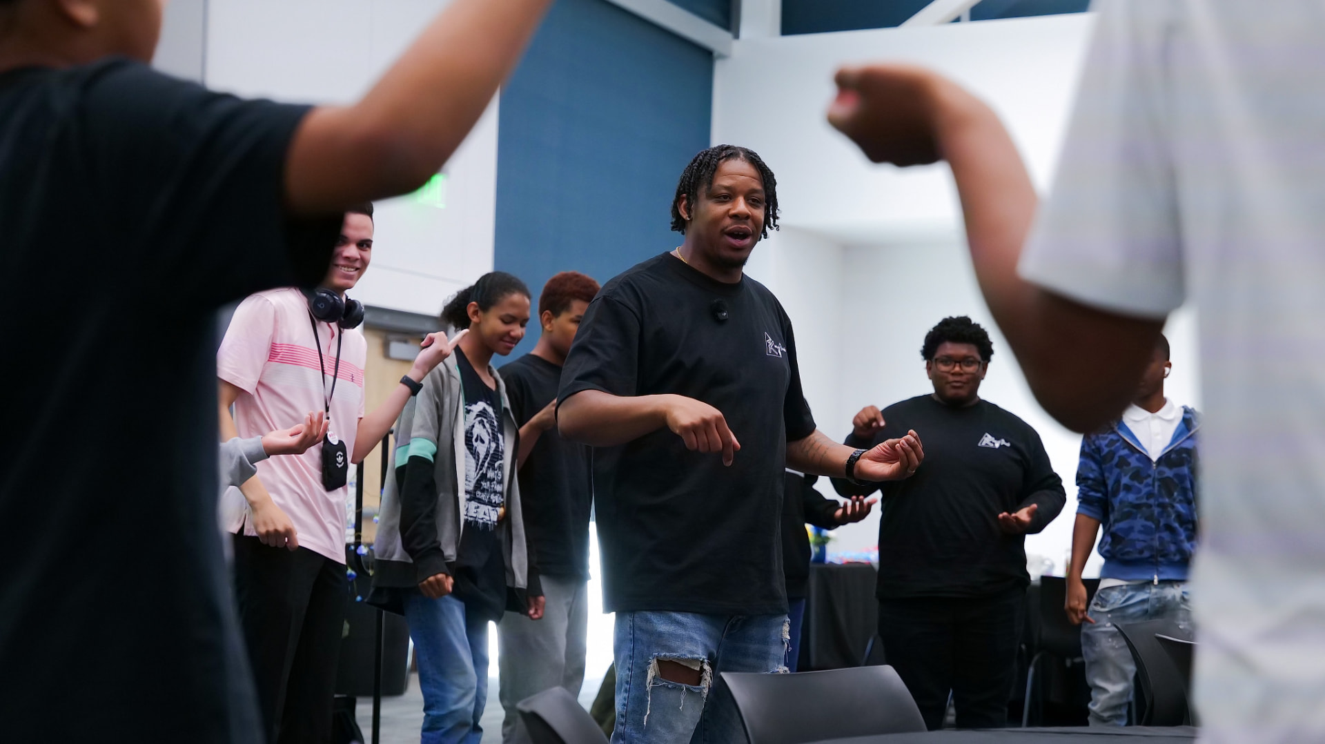 Mentor leading teens through an activity in a community center