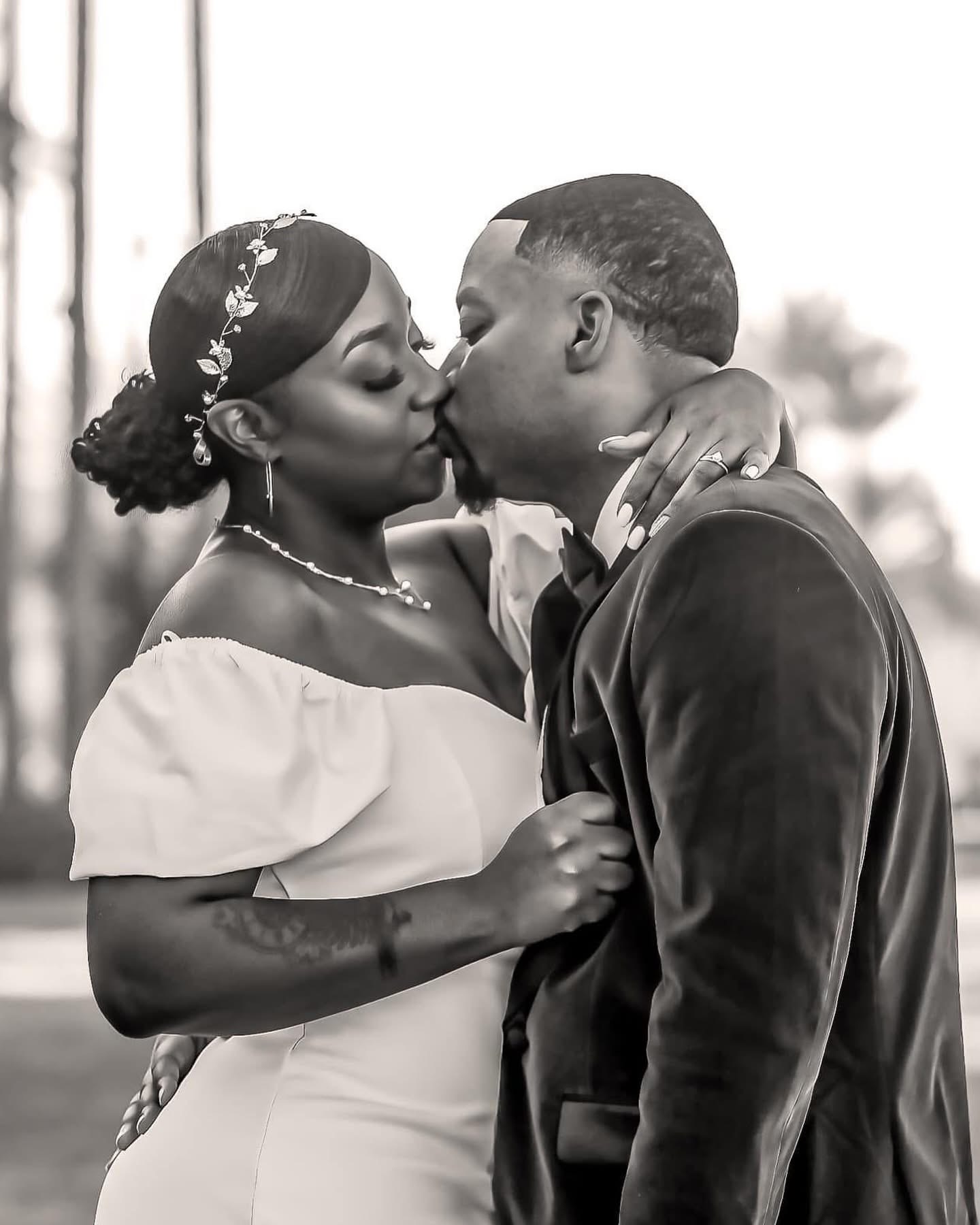 First kiss between bride and groom outdoors at golden hour