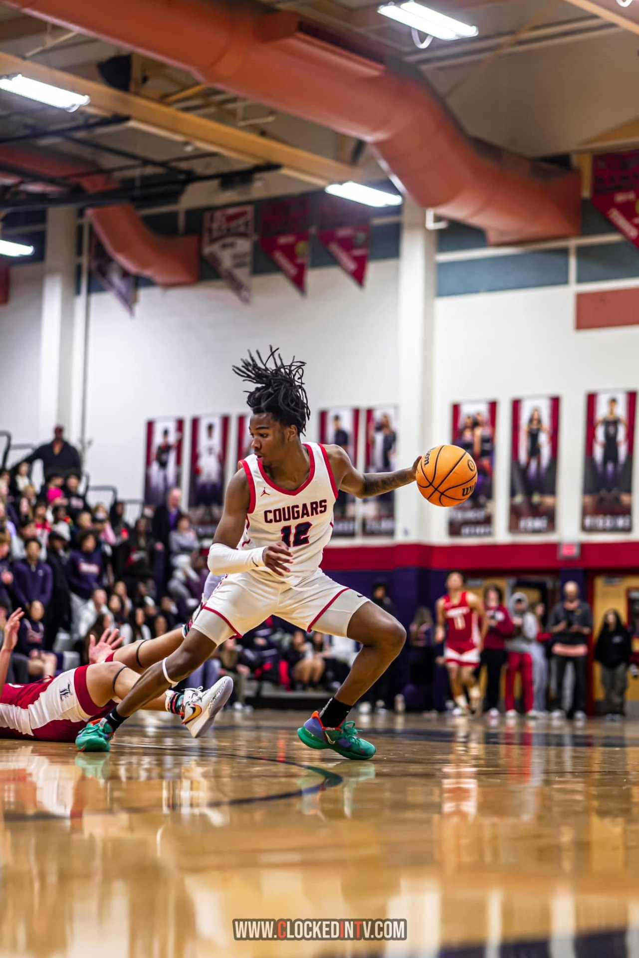 High school guard changing direction with the ball on a polished court