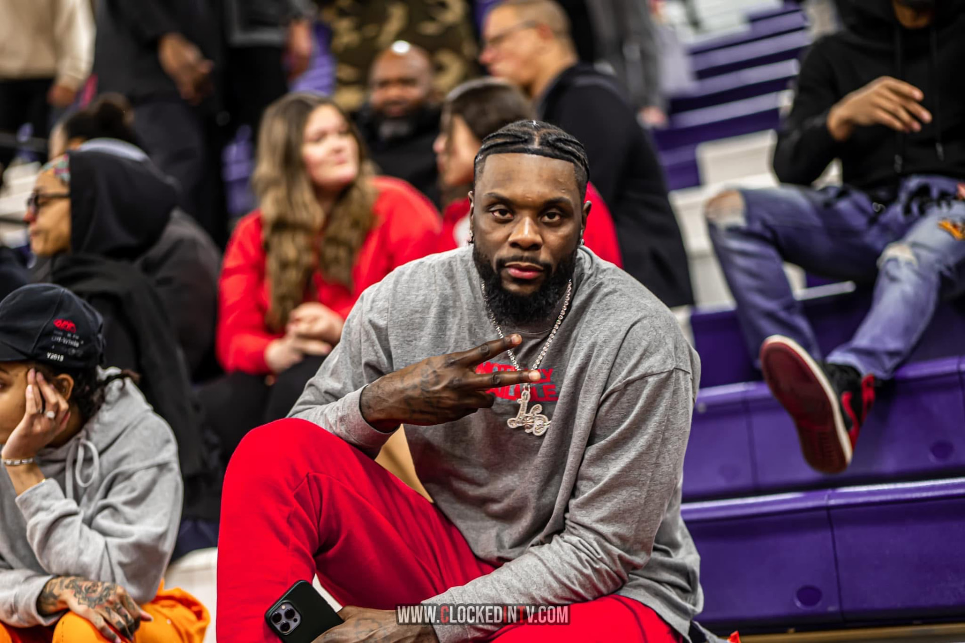 Athlete courtside in the stands throwing up a peace sign