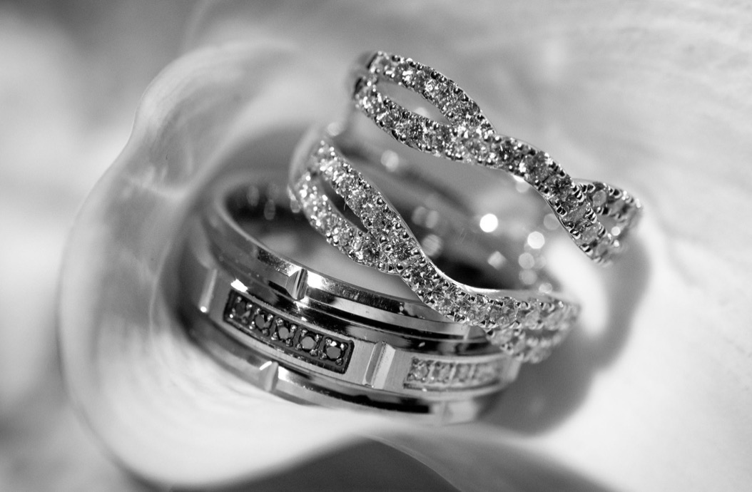 Bride and groom rings resting together on white satin