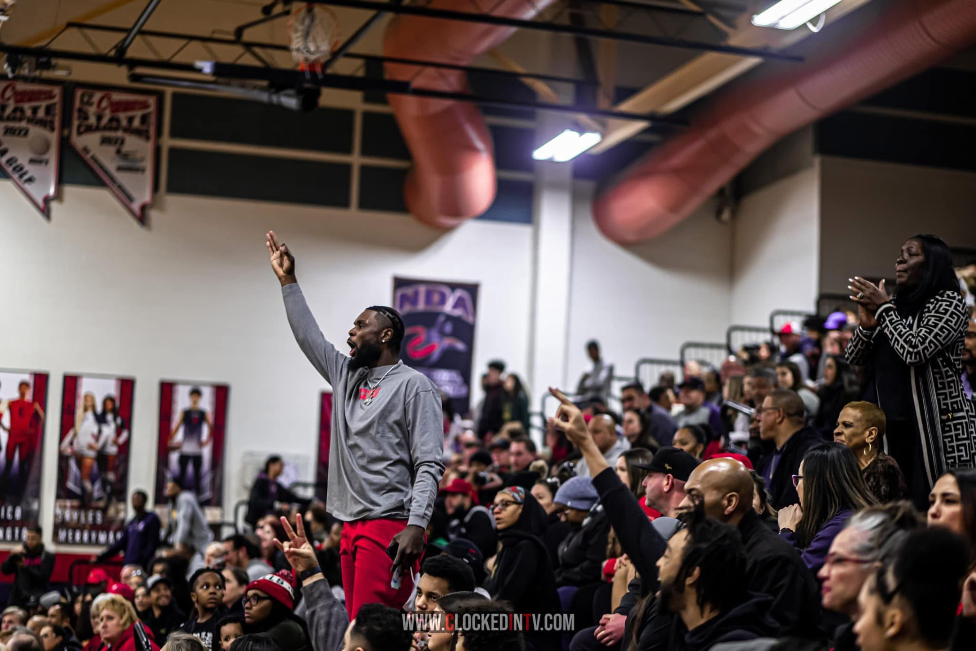 Coach signaling from the sideline as the crowd reacts