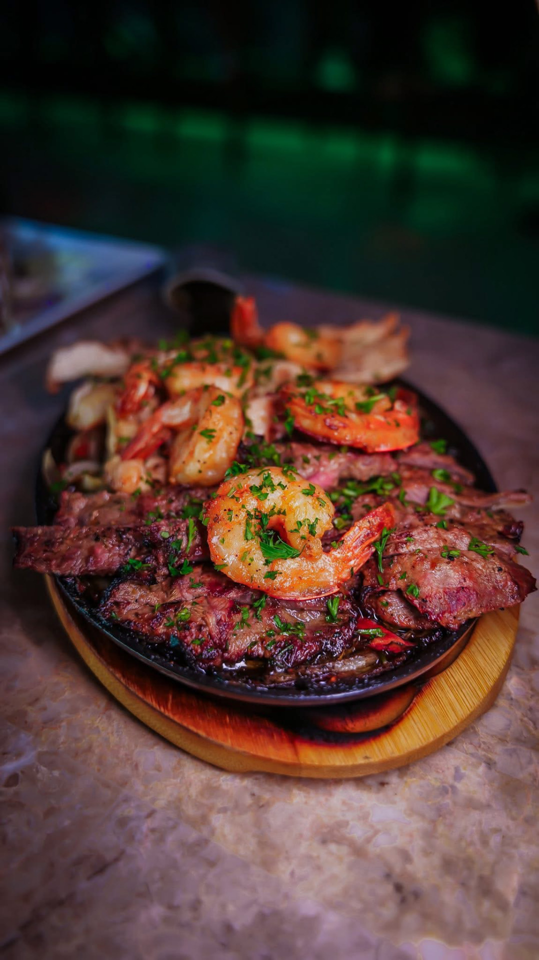 Sizzling steak and shrimp fajita platter under warm restaurant light