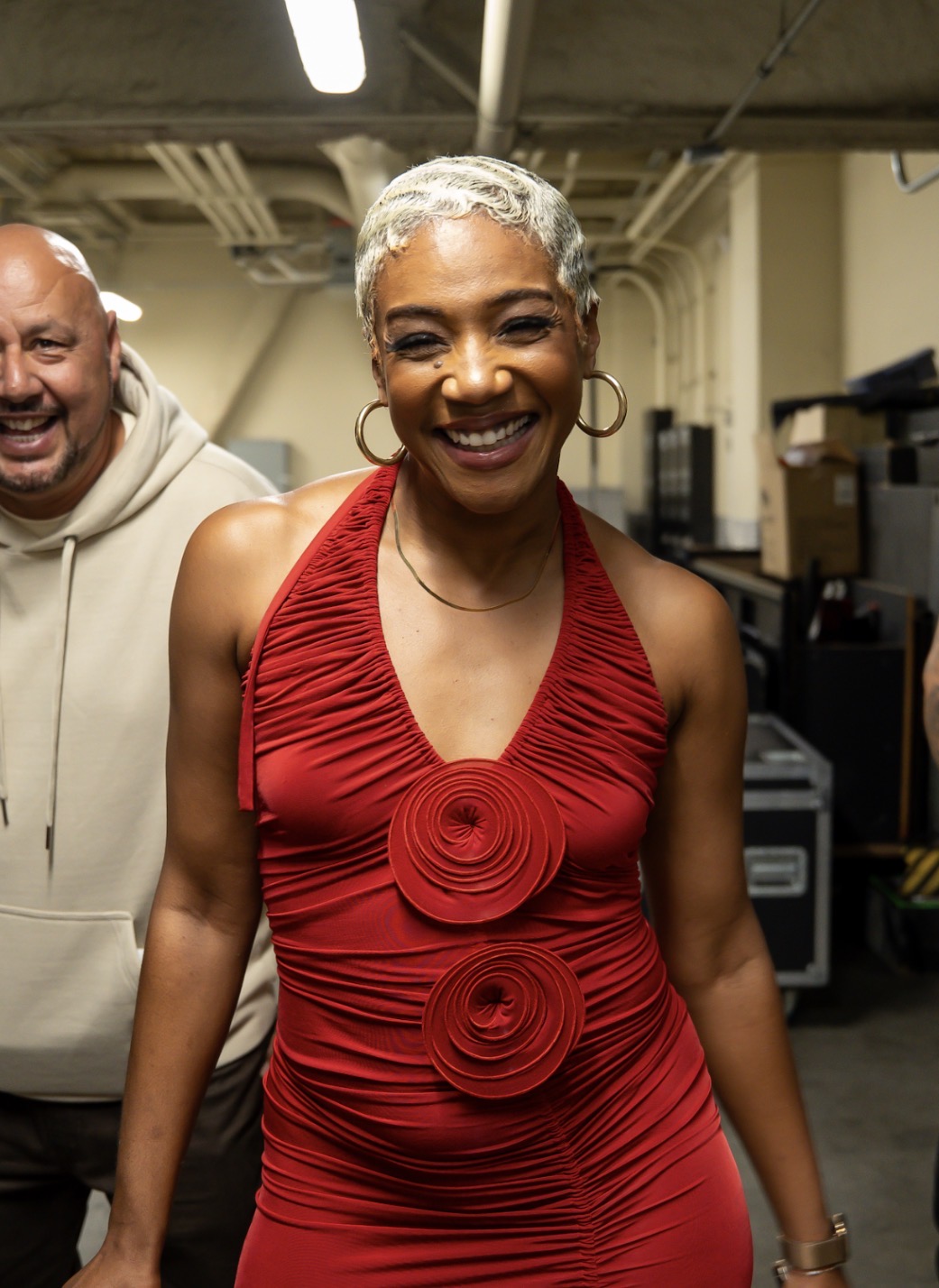 Actress in a red dress laughing backstage before showtime
